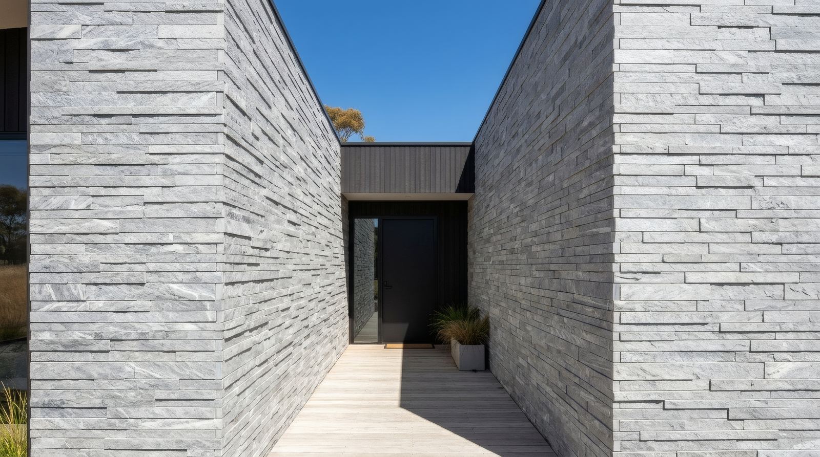 Grey stacked-stone cladding on a modern home entry passage